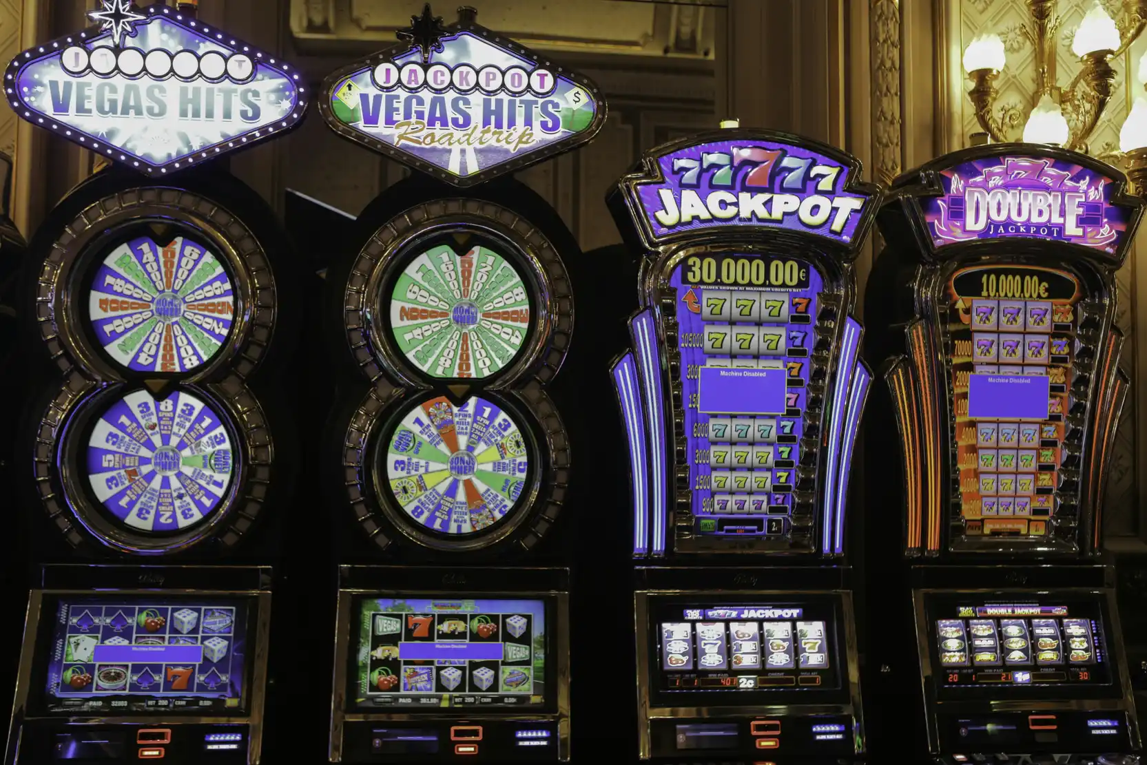 Rekke med opplyste spilleautomater på casino