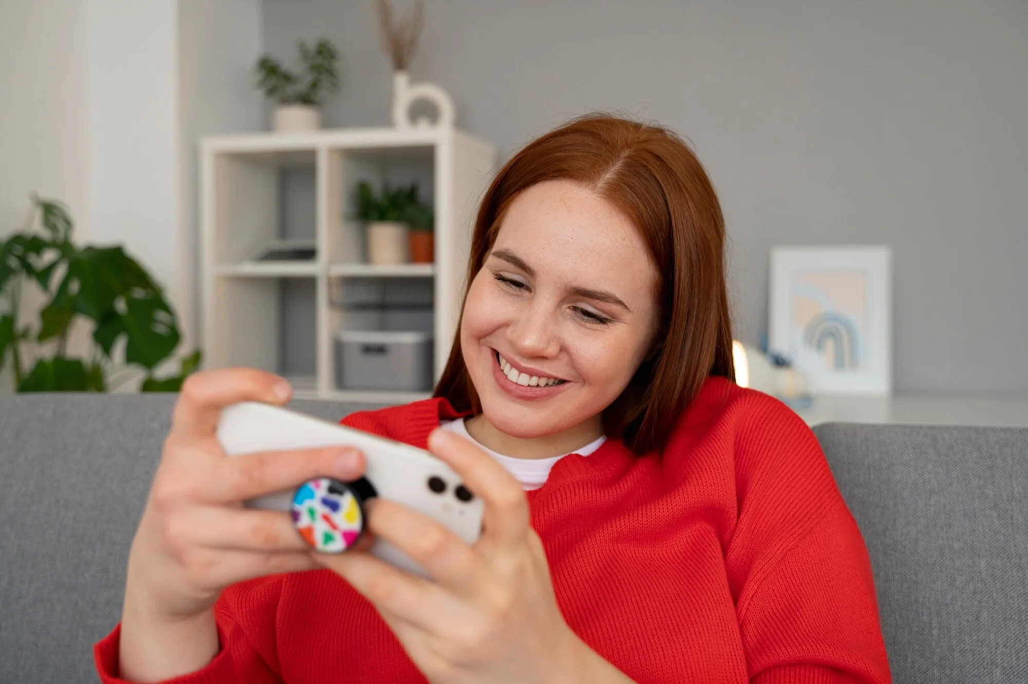 Kvinne som spiller på smarttelefon hjemme
